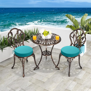 Two idee-home Round Outdoor Bistro Chair Cushions on two metal round chairs on a seaside terrace